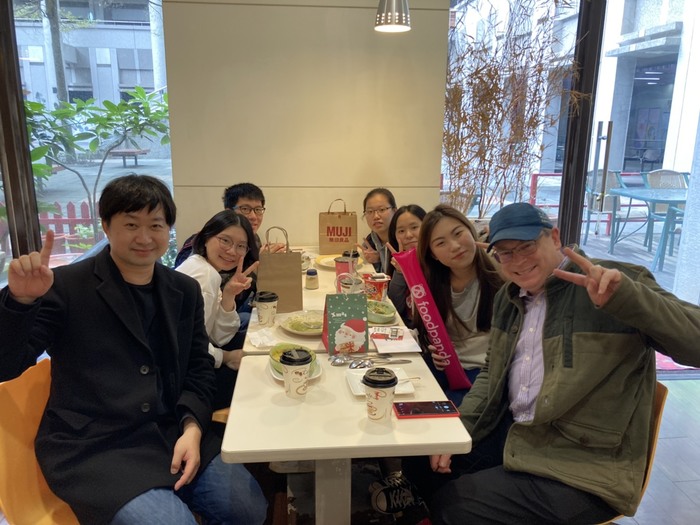 一位外國老師與英文老師跟學生在餐桌上合照