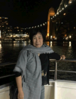 女性短髮批圍巾站在夜晚的碼頭